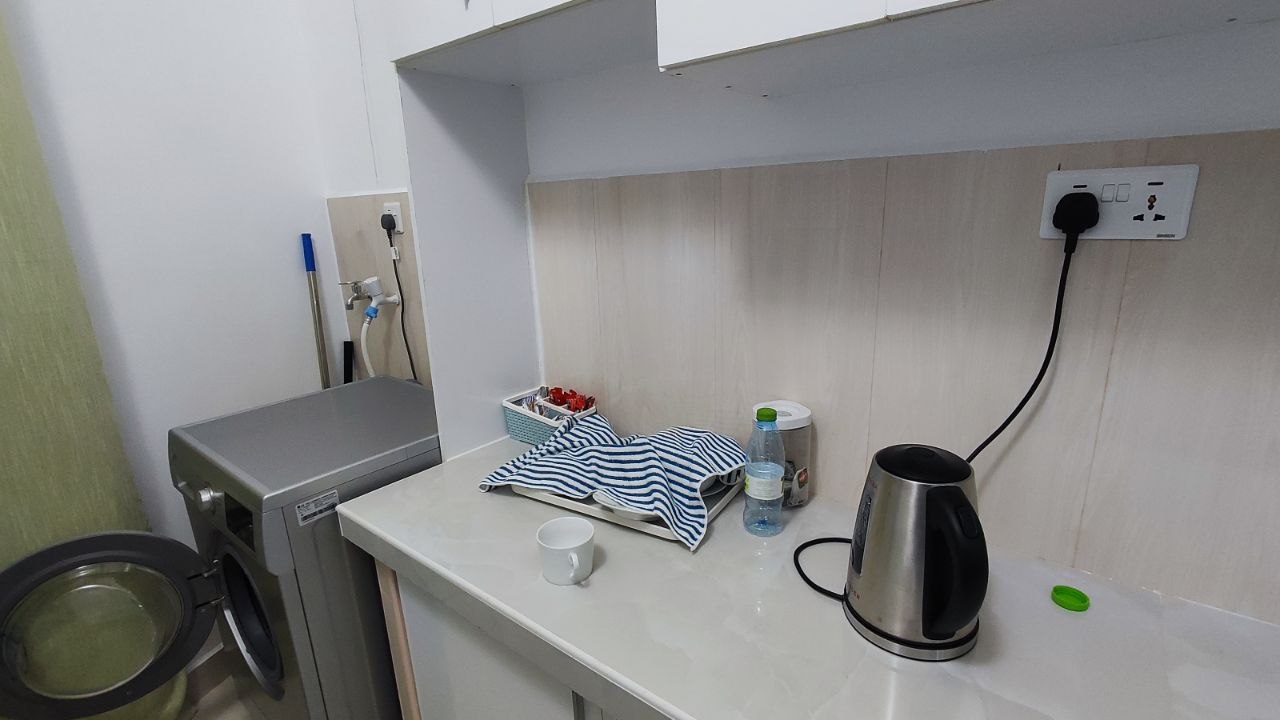 The kitchen with kettle and counter space, laundry area next to it