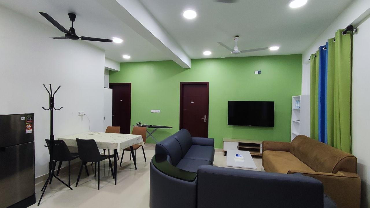 The sitting room with sofas, a dining area, and the kitchen behind